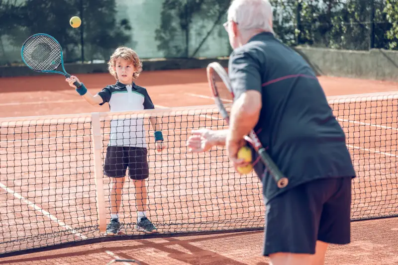 Tennis player teaching kid